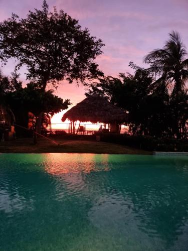 a pool of water with a sunset in the background at Eyes of the sea Piso 2 in Potrero