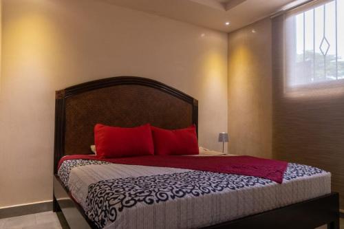 a bedroom with a bed with red pillows and a window at Eyes of the sea Piso 2 in Potrero