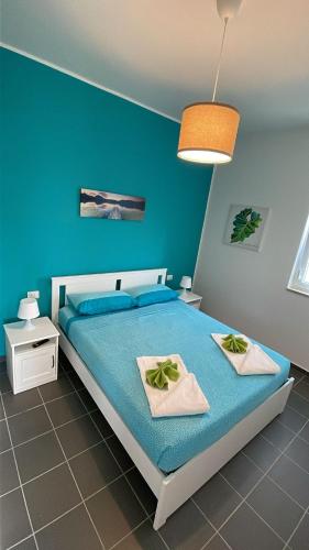 a blue bedroom with a bed with two towels at A 100 passi dal mare in Bari