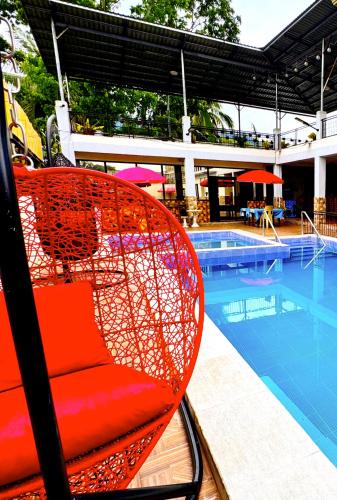 a red chair sitting next to a swimming pool at Julz Ridge Exclusive Place in Bayombong in Bayombong