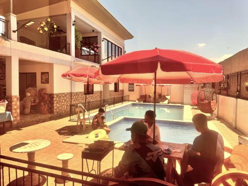 a group of people sitting at a table next to a pool at Julz Ridge Exclusive Place in Bayombong in Bayombong