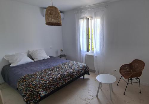 une chambre avec un lit, une table et une fenêtre dans l'établissement 140 m2 villa with pool in Pernes-Les-Fontaines, à Pernes-les-Fontaines
