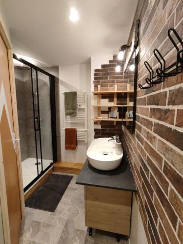 La salle de bains est pourvue d'un lavabo et d'un mur en briques. dans l'établissement Cozy appartement plagne Bellecote, à La Plagne Tarentaise
