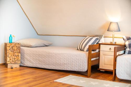 a small bedroom with a bed and a night stand at Telgártska chalupa pod Kráľovou hoľou - sauna & altánok in Telgárt