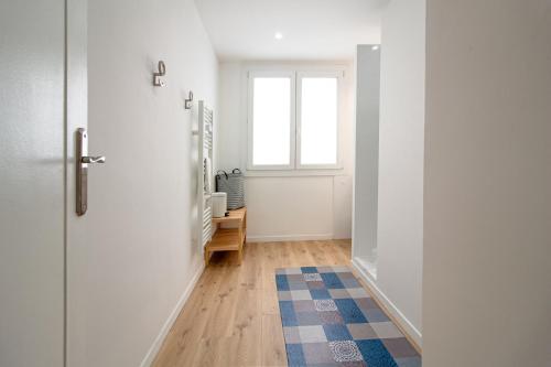 un couloir avec une porte et une fenêtre dans l'établissement Appartement T3 climatisé, cœur de Toulon, à Toulon