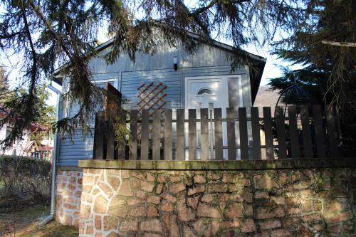 a blue house with a fence in front of it at Átkapcsol-LAK Vendégház in Csókakő