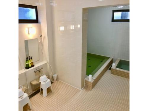 八戸市にあるHotel Tetora Hachinohe - Vacation STAY 38074vのバスルーム(緑のバスタブ、トイレ付)