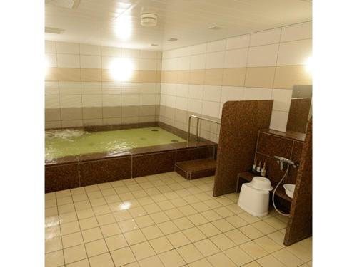 a bathroom with a bath tub with a green bath tub at Midosuji Hotel - Vacation STAY 41579v in Osaka