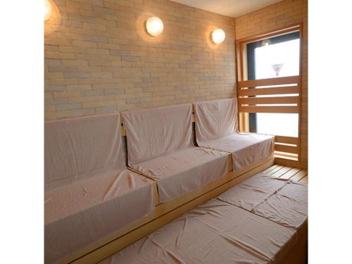a couch in a room with a brick wall at Midosuji Hotel - Vacation STAY 41579v in Osaka