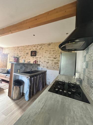 - une cuisine avec une cuisinière dans l'établissement Maisonnette avec terrasse de la Bellue, à Cézac