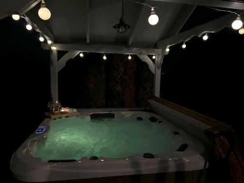 a jacuzzi tub in a room with lights at Átkapcsol-LAK Vendégház in Csókakő