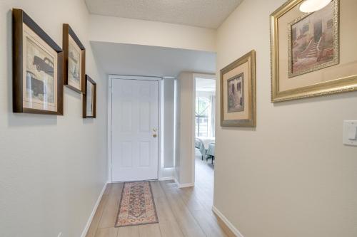 a hallway with a white door and paintings on the walls at Patio and Pool Access Golf Getaway in Peoria in Peoria