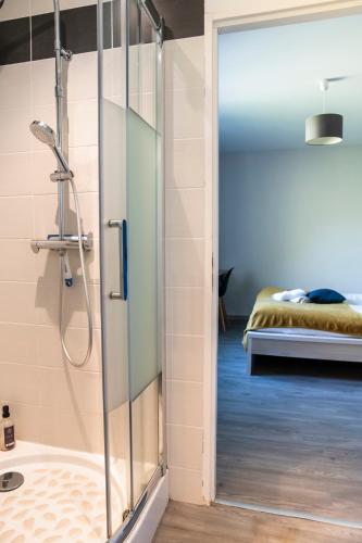 - une douche avec une porte en verre dans la chambre dans l'établissement Jolie maison LE TEICH bassin Park/wifi, au Teich