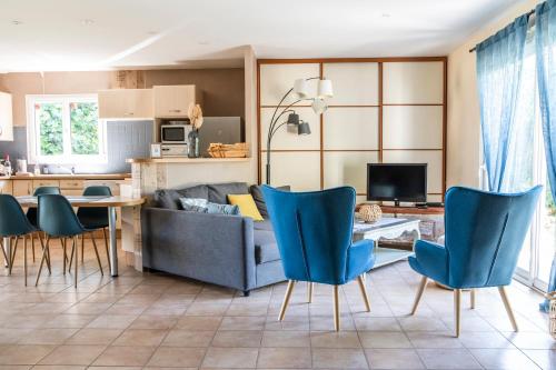 a living room with a couch and a table and chairs at Jolie maison LE TEICH bassin Park/wifi in Le Teich