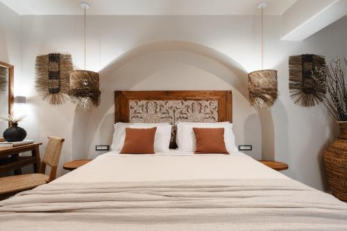 纳克索乔拉Chic Elysium - Felicity的卧室里有一张白色的大床，上面放着橙色的枕头