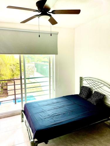 a bedroom with a bed and a ceiling fan at Quinta Colinas Oaxtepec in Oaxtepec