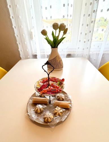 a table with a bowl of food and a vase at Apartments Aurora in Zadar