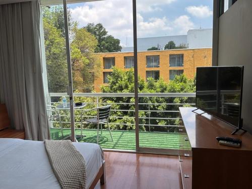 ein Schlafzimmer mit einem Bett und einem großen Fenster in der Unterkunft Lombardo Suites in Mexiko-Stadt