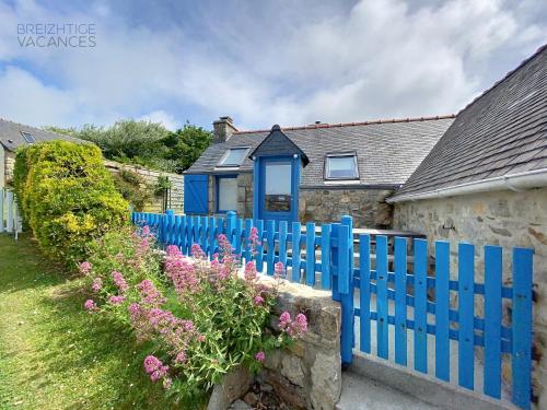 une clôture bleue devant une maison fleurie dans l'établissement Penty Kersiguénou à Crozon - Vue mer, à Crozon