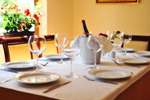 a table with plates and wine glasses on it at Hotel Vila e Arte City Center in Tirana