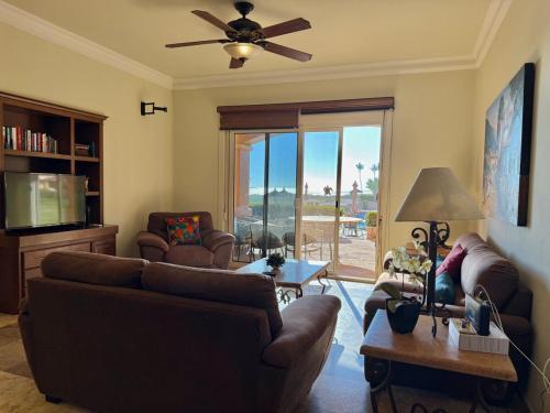 a living room with couches and a ceiling fan at Depa en EDM planta baja a pie de playa in Mazatlán