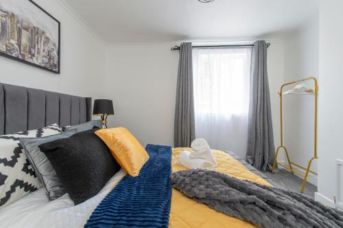 a bedroom with a bed with black and yellow pillows at Luna Homes in Dartford