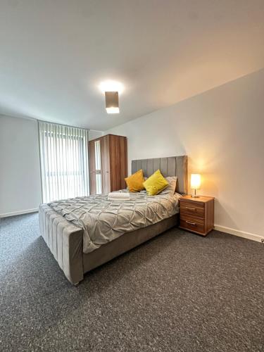 a bedroom with a bed with yellow pillows on it at 2 Bed ensuite with Balcony and Free onsite Secure Parking in Manchester