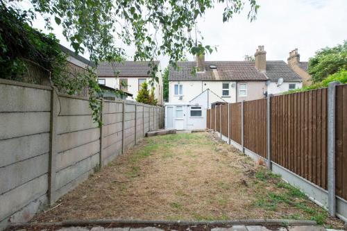 a fence in a yard next to some houses at Luna Homes in Dartford