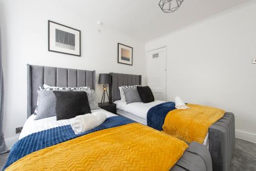two beds sitting next to each other in a bedroom at Luna Homes in Dartford