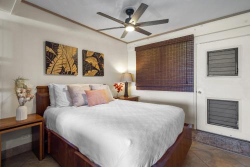 a bedroom with a bed and a ceiling fan at Direct Oceanfront Beach Pohailani Studio - New in Kahana