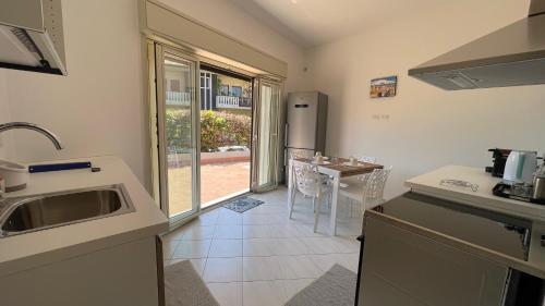 a kitchen with a sink and a table with chairs at Casa Sciarelli in Aci Castello