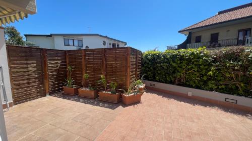 a wooden fence with potted plants on a patio at Casa Sciarelli in Aci Castello