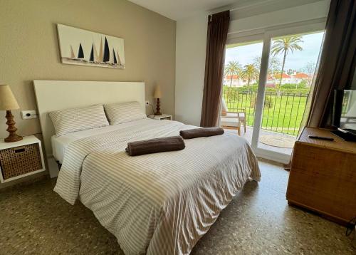 a bedroom with a bed and a tv and a window at Relax en playa de l'Ahuir Gandia in Playa de Gandia