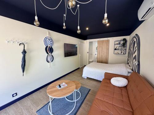 a bedroom with a bed and a table and a couch at Studio indépendant proche aeroport Nantes in Saint-Aignan-Grand-Lieu