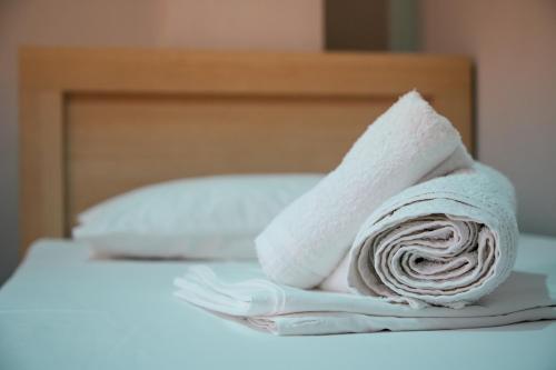 a roll of white towels sitting on a bed at Gega's Apartment in Gjirokastër