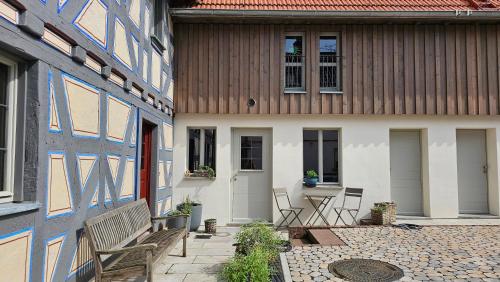 a patio with chairs and a table in front of a building at Designerwohnung im preisgekrönten Denkmal in Groß-Umstadt