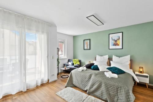a bedroom with a bed and a large window at Harmonie Homes - Built in 2025 - Hotel-Quality Beds & Linen - Full Kitchen - Fiber WiFi - 4K Smart TV - 2 Balconies - Elevator - Free Private Parking - Near Augsburg - 20 Min via Autobahn to Munich-West in Dasing