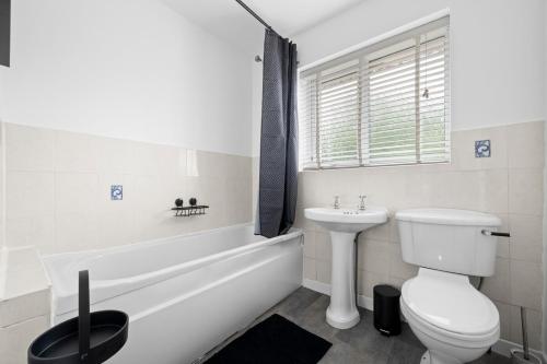 ein weißes Badezimmer mit Toilette und Waschbecken in der Unterkunft Three Bedroom House by Brookland Stays Serviced Accommodation Short Lets Wigan with Free WiFi in Hindley
