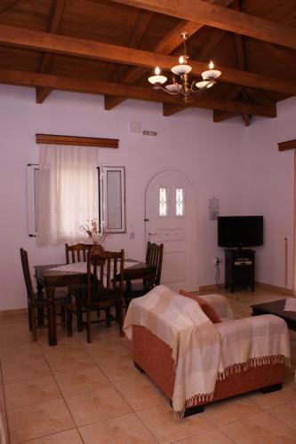 a bedroom with a bed and a table and a television at Villa Hector in Lefkada