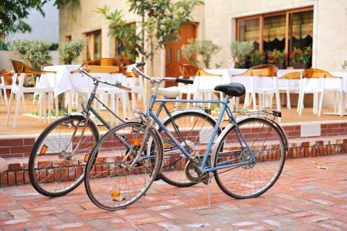 two bikes parked on a brick sidewalk with tables and chairs at Hotel Vila e Arte City Center in Tirana