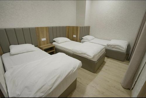 a room with three beds in a room at Lara Hotel in Duhok