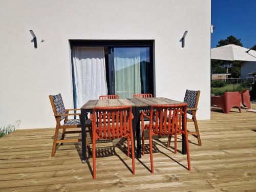 une table et des chaises en bois sur une terrasse dans l'établissement Villa Coco Ocean famille and spa, à Vielle-Saint-Girons