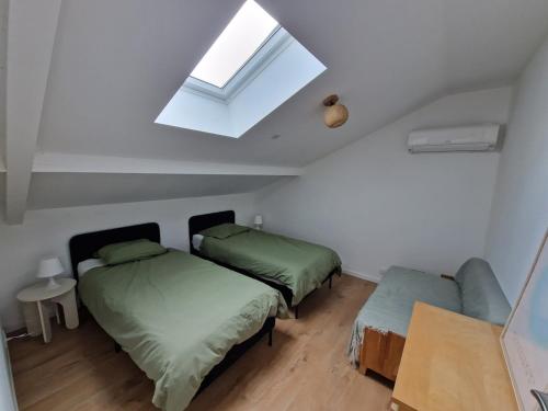 - une chambre avec 2 lits et une lucarne dans l'établissement Villa Coco Ocean famille and spa, à Vielle-Saint-Girons