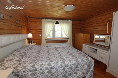 a bedroom with a bed in a wooden cabin at Herralan huvila lähellä PowerParkia Kauhava in Kauhava