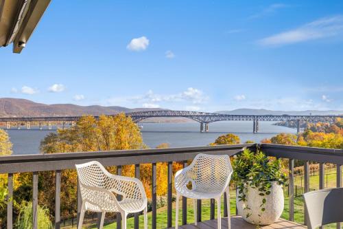 a balcony with two chairs and a view of a bridge at Hudson House in Newburgh