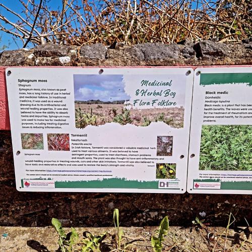 a sign on the side of a wall with plants at Castle view Cabin 