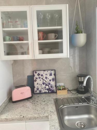 a kitchen counter with white cabinets and a sink at Casa Dos Jotas in Costa Calma