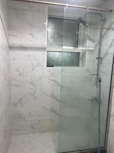 eine Dusche mit Glastür im Badezimmer in der Unterkunft عجمان in Sabkhah