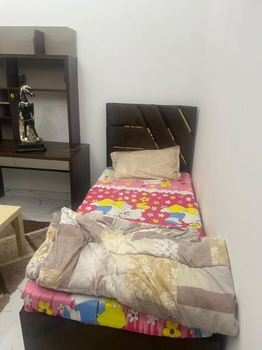 ein Bett mit einer bunten Decke darauf in der Unterkunft عجمان in Sabkhah