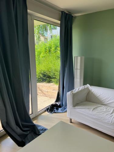 a living room with a couch and a window at Taunus Wohnen und Arbeiten mit eigener Terrasse in Friedrichsdorf